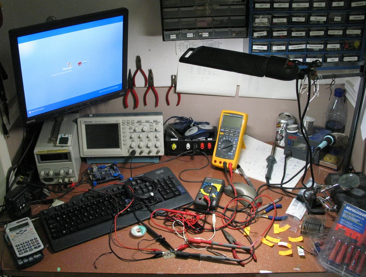 Source photograph: an electronics workbench with instruments and tools